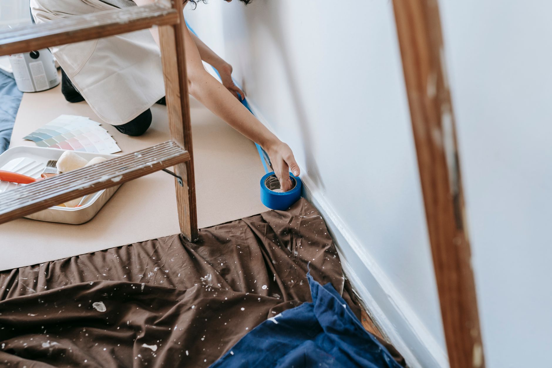 Person taping trim before painting
